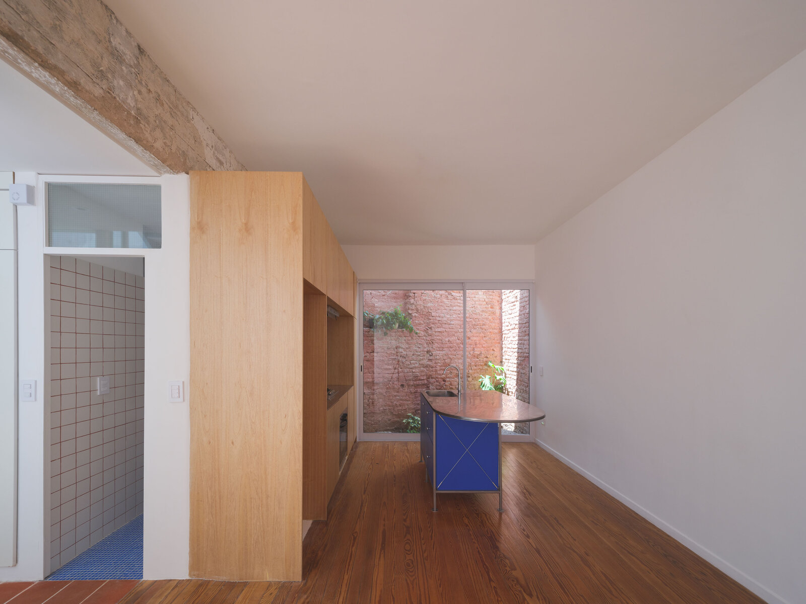 Circulación interior con pisos de pinotea restaurados y cocina al fondo