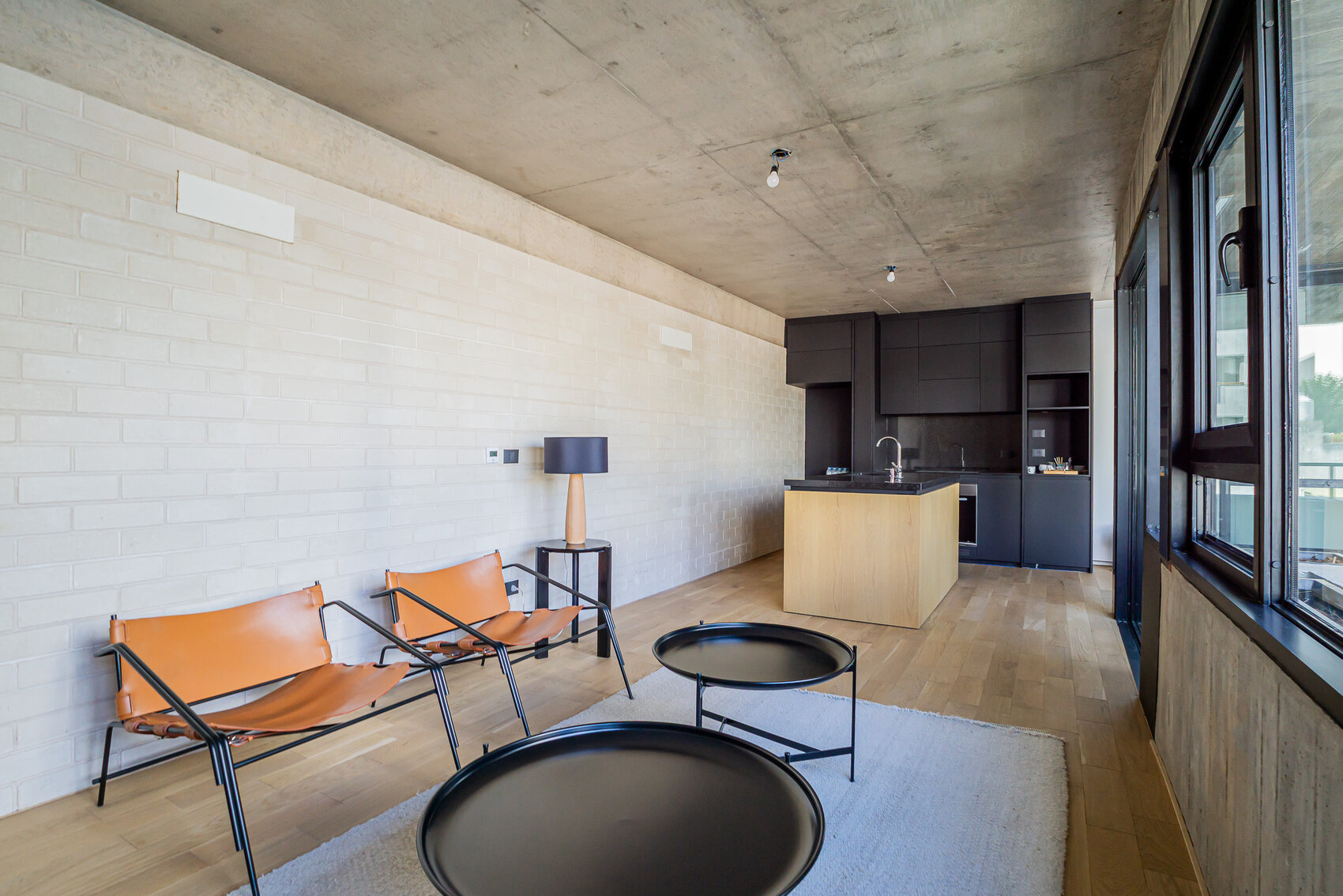 Living con sillones y grandes ventanales