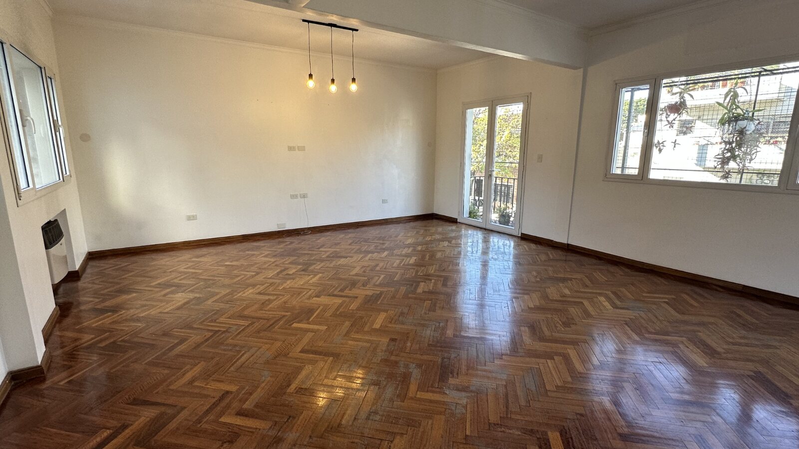 Living amplio con parquet y balcón