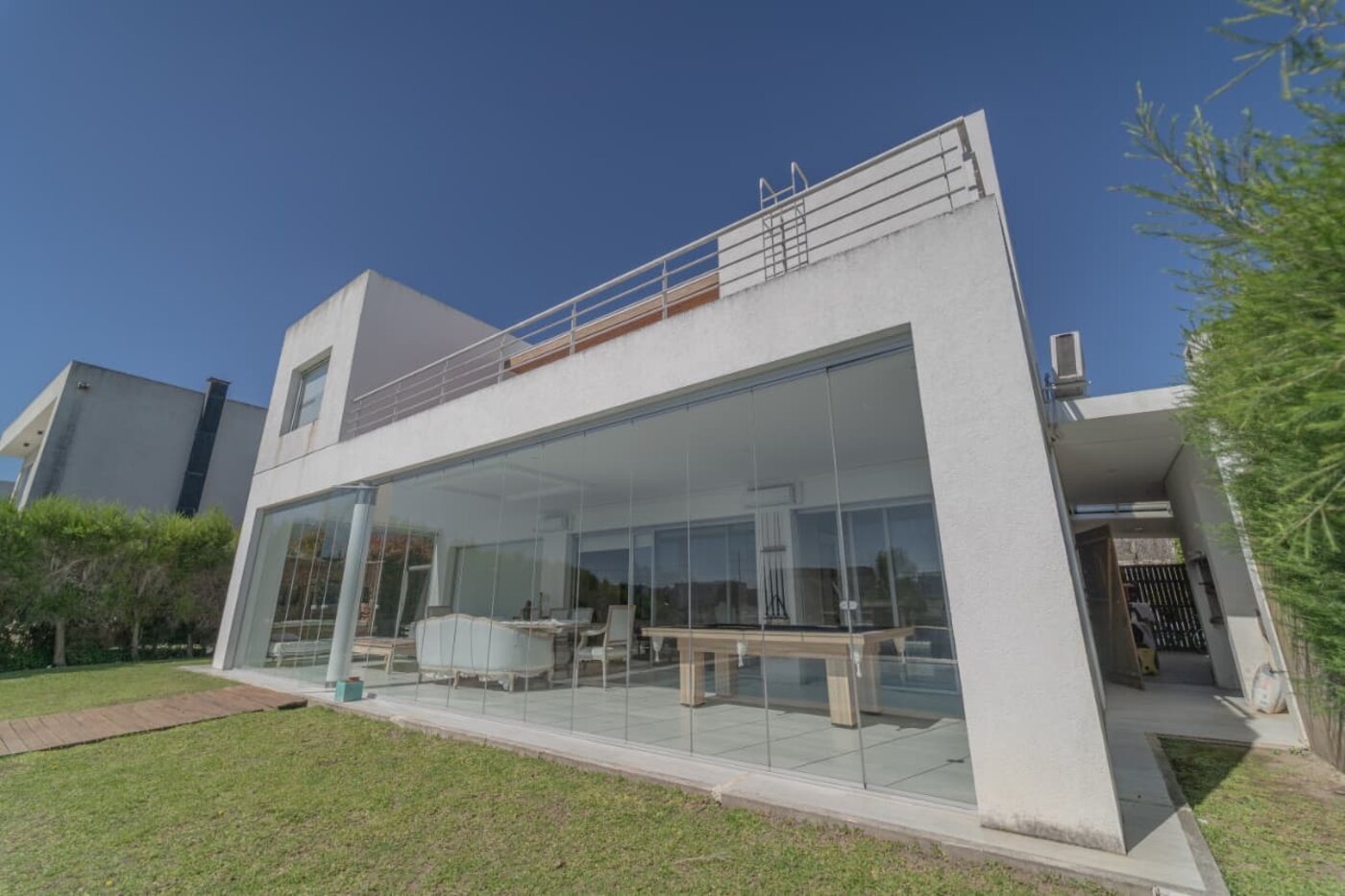 Frente vidriado de la casa con salida al parque