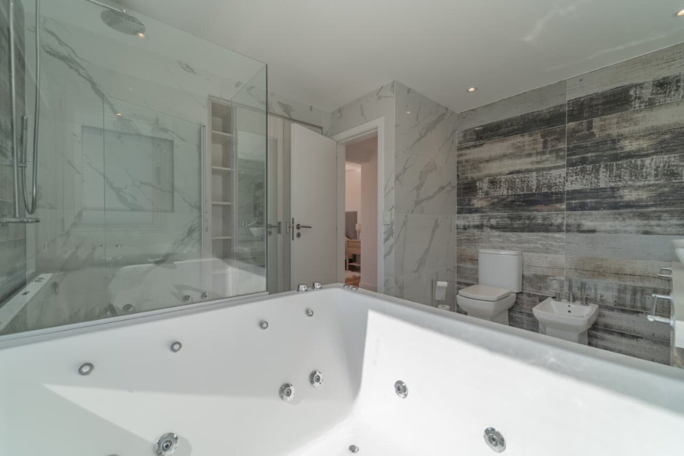 Baño con jacuzzi y revestimiento en mármol