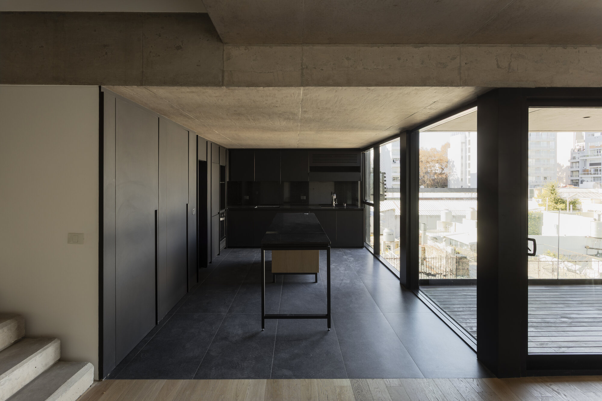 Cocina con isla y mesada de granito, integrada al living con vista a la ciudad