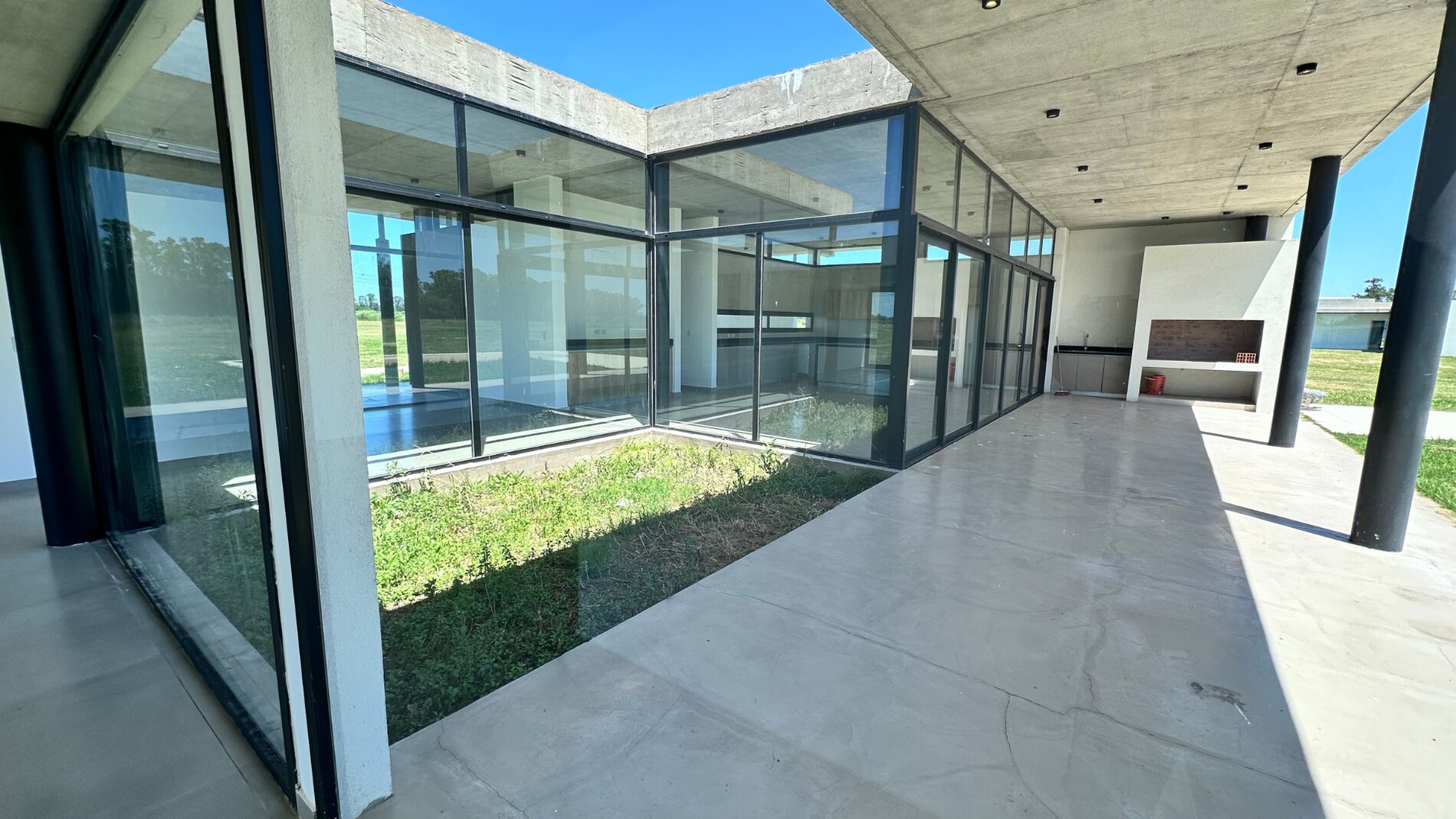 Patio interno vidriado que integra luz y verde a los ambientes