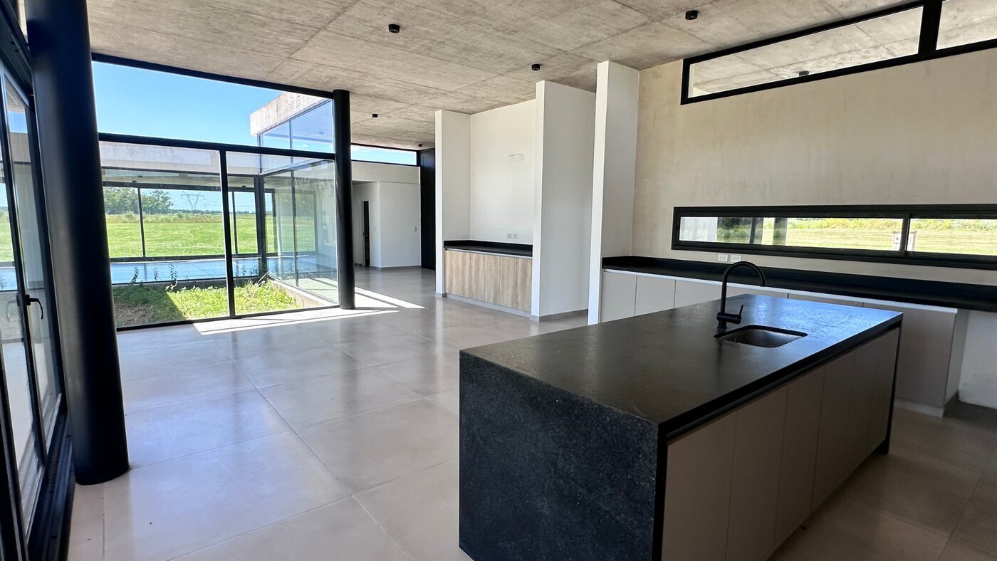 Cocina con isla integrada al living y grandes ventanales