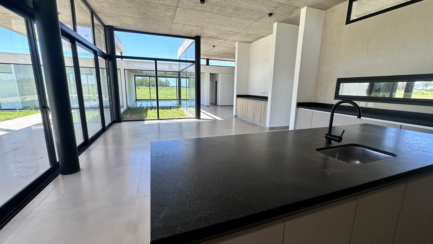 Isla de cocina con mesada negra y vista al parque