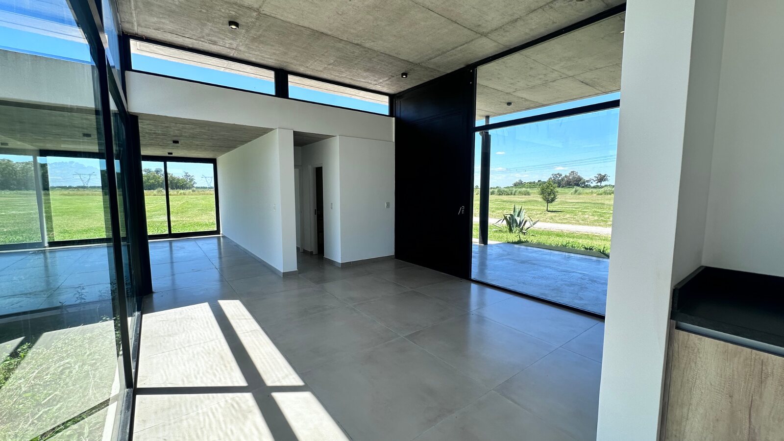 Living comedor amplio con ventanales de piso a techo al patio