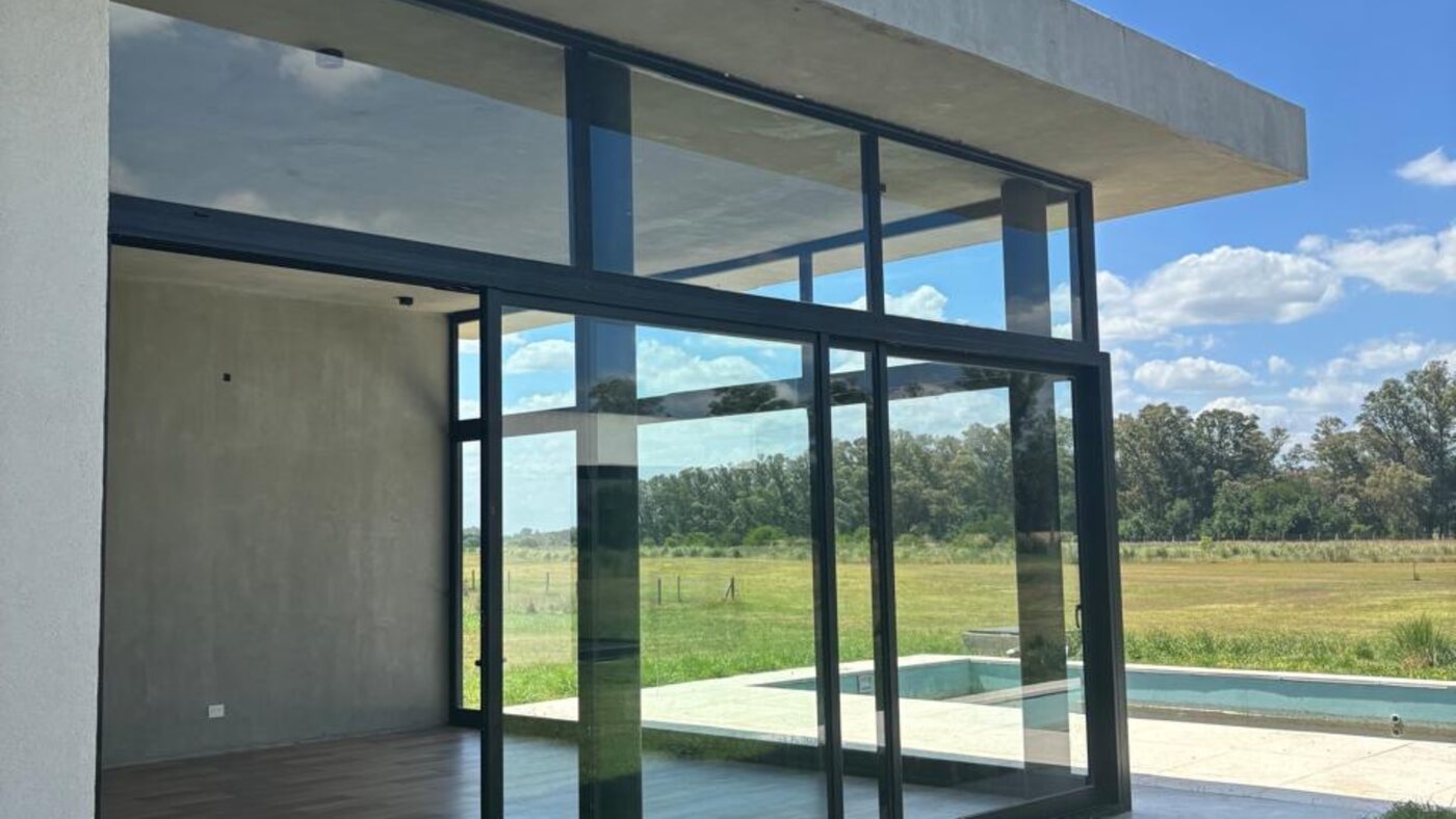 Galería y living abiertos a la piscina y el golf